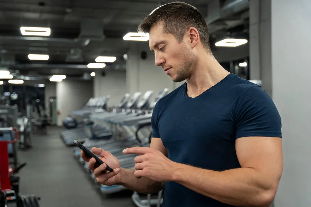 Man using a smartphone in a gym setting